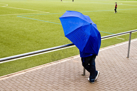 伞下的人正在看足球赛图片