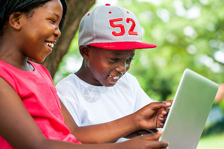 非洲青少年在公园里享受笔记本电脑时间图片