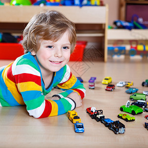 有趣的小男孩在室内家里或托儿所玩很多玩具车孩子男孩穿着五颜六色的衬图片