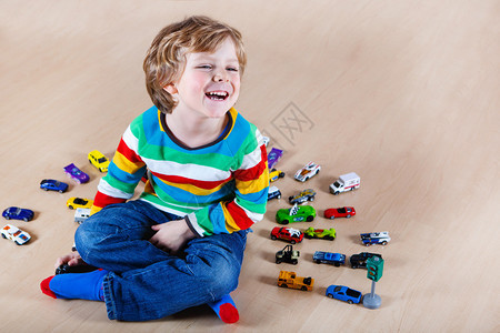 有趣的小孩在室内玩具车图片