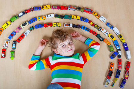 可爱的金发小男孩在室内玩很多玩具车孩子穿着五颜六色的衬衫快乐的学龄前儿童在家里或托儿所玩得开心不同车辆的大集图片
