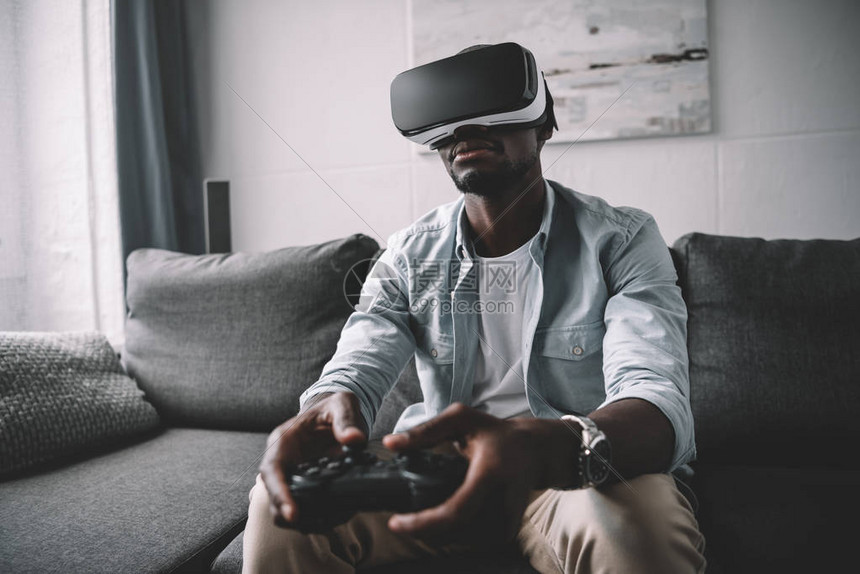 非裔美国人在家里使用虚拟现实头耳机和游戏图片