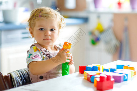 可爱的蹒跚学步的女孩在幼儿园玩益智玩具快乐健康的孩子在家里玩五颜六色的不同塑料块可爱的宝学图片