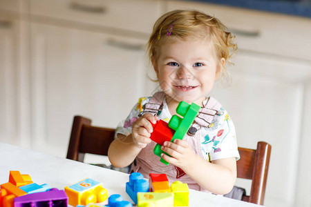 可爱的蹒跚学步的女孩在幼儿园玩益智玩具快乐健康的孩子在家里玩五颜六色的不同塑料块可爱的宝学图片