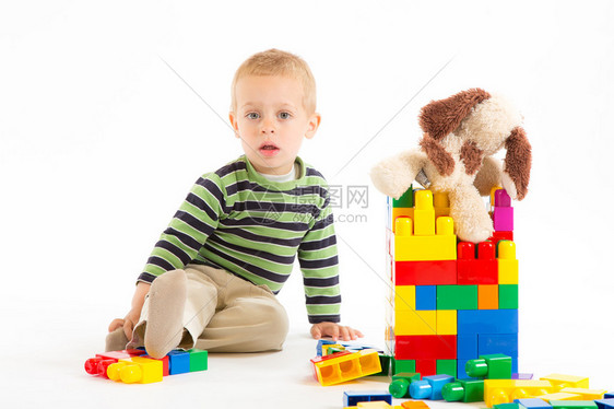 可爱的小男孩在玩塑料建筑块图片