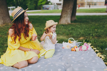 穿着黄色连衣裙的微笑女人在公园的绿草上玩耍图片