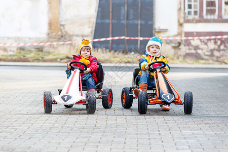 两个快乐活跃的小孩和兄弟姐妹在户外玩具赛车有比赛的朋友儿童概图片
