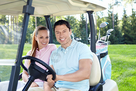 在高尔夫球车里的年轻夫妇图片