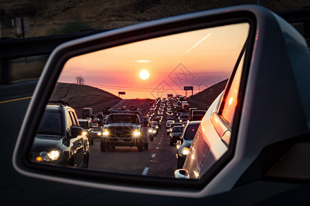 日出时后视镜中的交通拥堵和大灯图片
