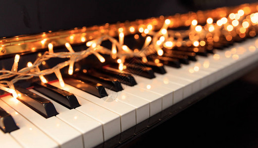 古典钢琴键盘上的圣诞灯背景图片