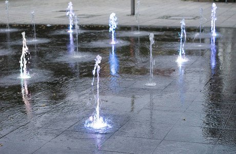 晚上在城市喷泉里喷洒水流图片