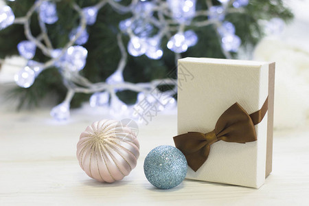 一个充满欢庆的静世节带着礼物在白盒子里有棕弓粉红和浅淡蓝色圣诞树球圣誕树上装饰图片