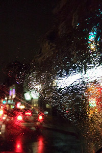 夜间五颜六色的灯光透过潮湿的车窗图片