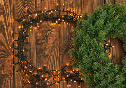 由美丽明亮的圣诞灯光和木本底花环组图片