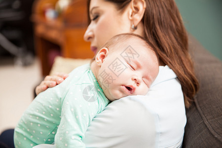 一个可爱的新生女婴的肖像睡在母亲的图片