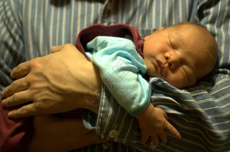 婴儿睡在他父亲的手里图片