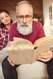 专心留胡子的男人在看书而女图片