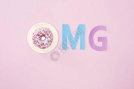 OMG顶端视图符号由字母和粉红色的冰甜圈分离而成巧克力甜圈背景图片