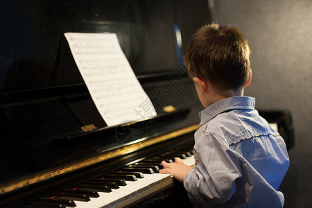 一个小男孩学习钢琴彩色图像的剖面图图片