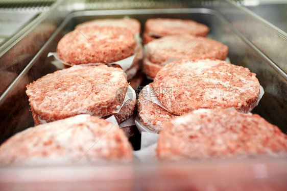 在餐馆或屠宰场用防油纸隔开的冷冻地牛肉汉堡图片