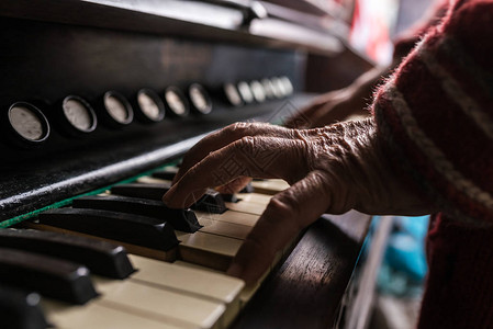 老人在玩风琴的时候近距离地看他的皱纹手在键盘上图片