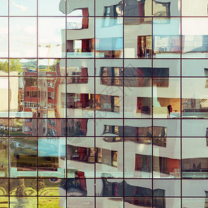 现代建筑反映在另一栋建筑的玻璃立面上图片