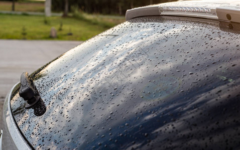 一辆银色汽车在后黑窗上的雨滴后面有图片