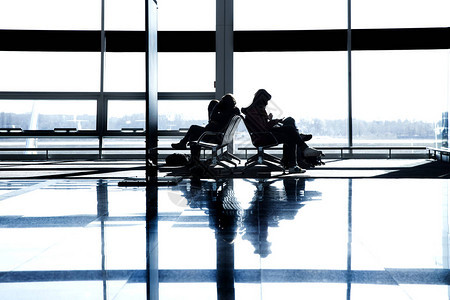 窗户背景下的大型机场乘客剪影旅客在机图片