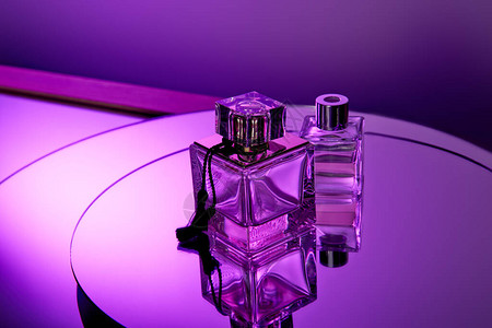 紫色玻璃香水瓶子在紫周镜图片