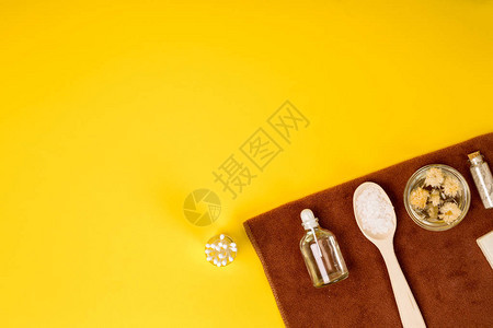 Spa或白色的健康设置黄色背景上装有精油毛巾海盐的瓶子文本的图片