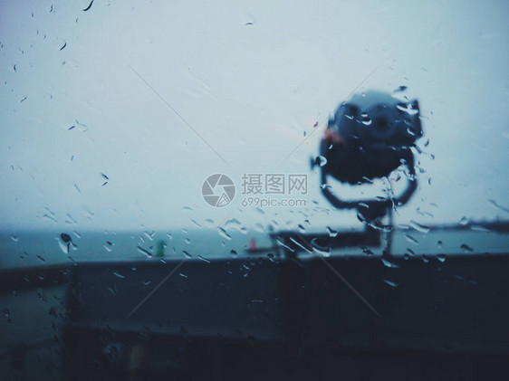 一艘在雨天的船上的探照灯通过一个湿润的图片