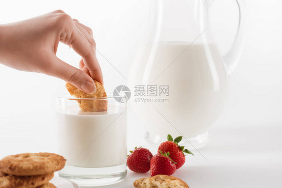 以新鲜牛奶和草莓为食用饼干的人近图片