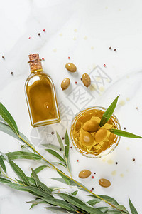 大理石桌子上装有橄榄油的瓶子和玻璃的顶视图图片