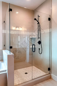 带半玻璃外壳和黑色淋浴头和把手的淋浴间浴室内部配有内置浴缸和墙壁和图片
