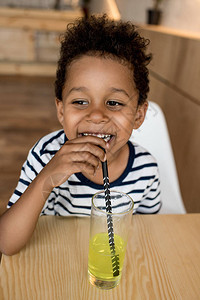 在咖啡馆喝果汁的非裔美国男孩笑图片
