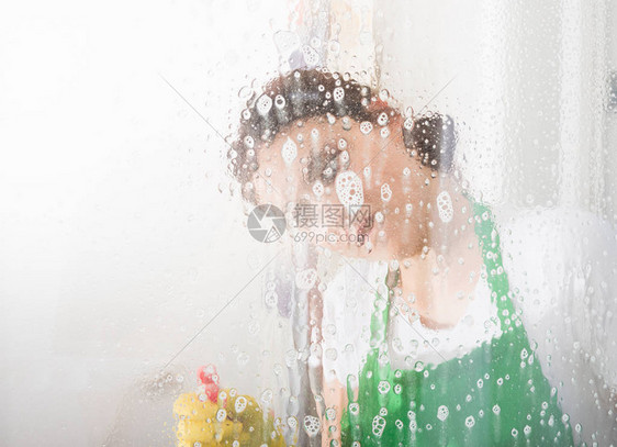 家务妇女用喷雾清洗窗户以清图片