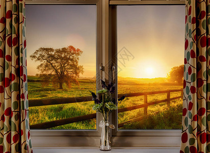 看着一扇窗在春天穿过田地和栅栏的美丽农村日出图片