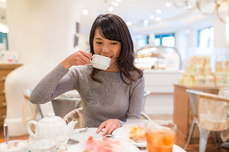 在蛋糕店喝茶的女人图片