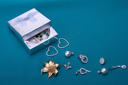 蓝色背景上带有漂亮珠宝的珠宝盒背景图片