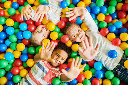 3个快乐的小孩在球坑里图片