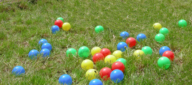 草丛中的彩色塑料球图片