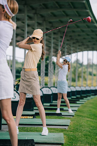 在高尔夫球场打高尔夫球的女高尔夫球手图片
