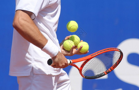 网球运动员检查球拍上的球背景图片
