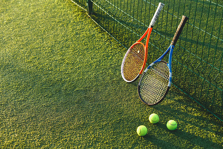 网球和拍在网球场的阳光下在草地上打网球的设备图片