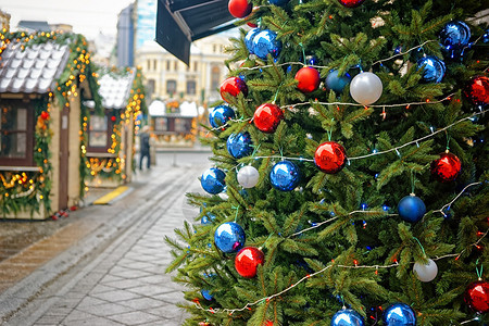 街头市场圣诞树上的红和蓝色装饰球红背景图片