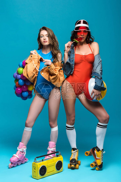 两个穿着溜冰鞋的时尚女孩吃蓝色西瓜棒图片