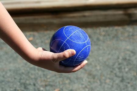 一只手拿着一个蓝色的地掷球背景图片