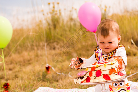 婴儿女孩用蛋糕和气球庆祝她第背景图片