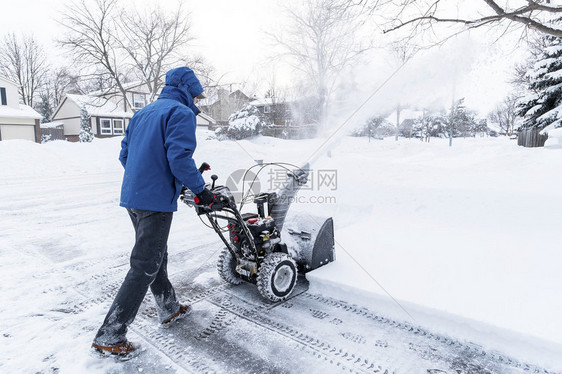 男人推着吹雪机图片