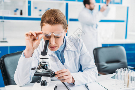 通过显微镜观察与实验室同事一起在工作场所的试剂图片